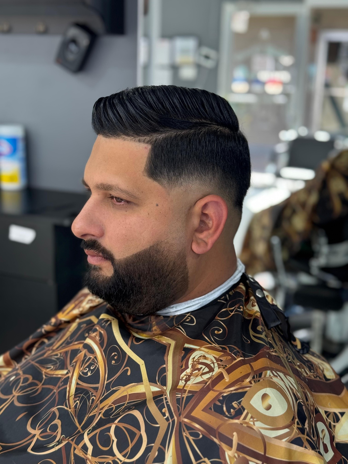 Slick back pompadour with skin fade and beard